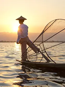 Intha leg rowing fishermen sunset on Inle Lake who row traditional wooden boats using their leg and fish using nets stretched over conical bamboo frames, Inle Lake, Myanmar (Burma), Southeast Asia