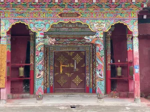 Symbolism Prints: Intricate doorway of Tibetan monastery showcasing vibrant designs and symbols of Himalayan Buddhist culture in Yunnan