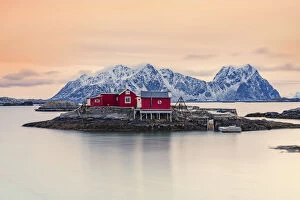 Nordland County Gallery: Isolated red fishermens cabins on rocks in the cold sea at sunset, Svolvaer, Nordland county