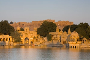 Images Dated 26th November 2007: Jaisalmer Fortress and Gadsisar Lake illuminated at sunrise, Jaisalmer, Rajasthan, India, Asia