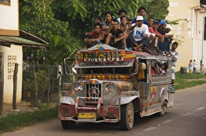 Jeepney truck with passengers crowded on roof