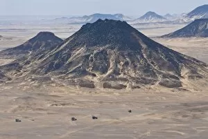 Jeeps passing little mountains in the Black Desert, Western Egypt, Egypt