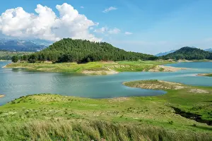 Wetlands Prints: Karacaoren dam lake showing turquoise water with greenery around mountains on a sunny day in Turkey
