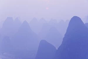 Karst landscape, haze and rising sun, Yangshuo, Guangxi Province, China, Asia