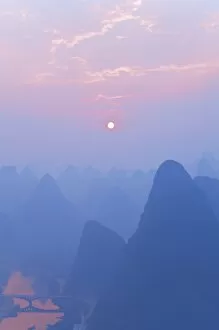 Karst landscape, Li Jiang (Li River) and rising sun, Yangshuo, Guangxi Province
