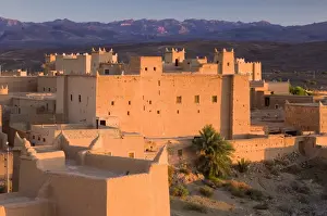 Kasbah bathed in evening light with the Jbel Sarhro Mountains in the distance
