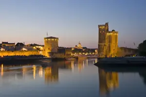 Charente Maritime Prints: La Chaine and St. Nicholas towers at the entrance to the ancient port of La Rochelle at dusk