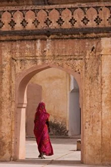 Images Dated 8th April 2010: Lady in traditional dress walking through a gateway in the Amber Fort near Jaipur