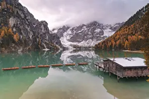 Boathouse Prints: Lake Braies (Pragser Wildsee) framed by colorful woods in autumn, Braies (Prags)