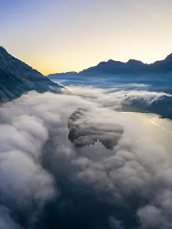 Drone Shot Prints: Lake Silvaplana and Sils hidden by the autumnal fog at dawn, aerial view by drone