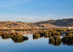 Peruvian Culture Prints: Lake Titicaca and cityscape of Puno at sunrise, Peru, South America