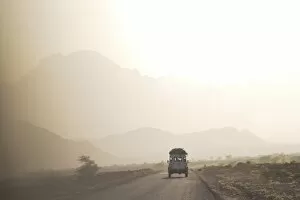 Dust Gallery: Land cruiser driving along dusty road, between Zagora and Tata, Morocco