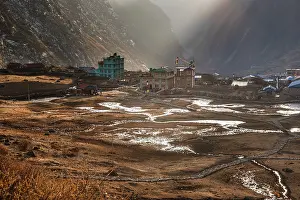 Lodges Prints: Langtang Village in soft morning light with scattered snow patches across terraced valley floor