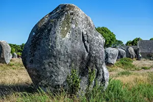 Geological Prints: Large stone stands in a field among other rocks under a clear blue sky in France during daylight hours