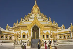 Large white and gold statues of chinthes stand guard at Swedawmyat Paya