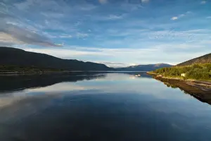 Midnight Sun Prints: Light of the midnight sun illuminates the clear water of blue sea and green woods