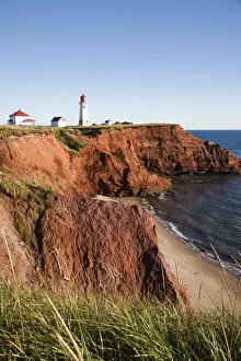 Lighthouse on a cliff overlooking a sandy beach on Havre-Aubert Island in the Iles de la Madeleine