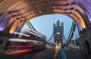 Double Decker Prints: Lights on Tower Bridge over the River Thames with a typical double decker bus, London