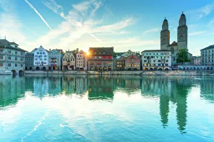 Rippled Gallery: Limmatquai and Grossmunster Cathedral mirrored in Limmat River at dawn, Zurich