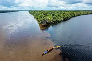 Rainforests Prints: Little boat on the meeting point of the Casiquiare River and black Pasimoni River