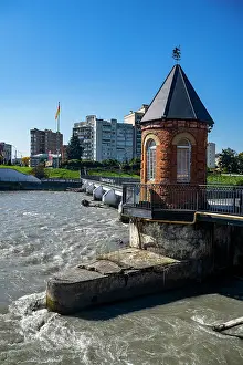 Riverbank Prints: Little bridge crosses Terek river in Vladikavkaz during bright sunny day in North Ossetia