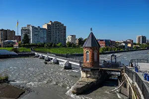Daylight Prints: Little bridge spans Terek river near city buildings in Vladikavkaz
