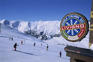 Livigno Prints: Livigno sign with skiers and mountains in the background