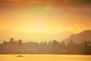 Fisherman Prints: A local fisherman in a traditional canoe in front of the ridges of the Banda islands