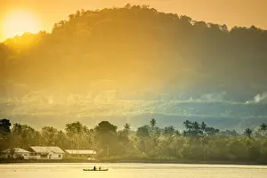 A local fisherman in a traditional canoe in front of the ridges of the Banda islands