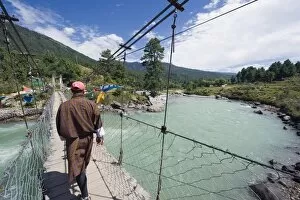 Images Dated 2nd October 2009: Local man crossing a bridge, Bumthang, Chokor Valley, Bhutan, Asia