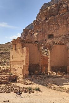 Rider Prints: Local man on donkey passes Qasr al-Bint temple, elevated view, City of Petra ruins