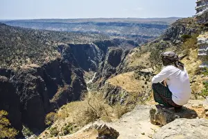 Wearing Prints: Local man looking at a huge canyon on the Dixsam plateau on the island of Socotra