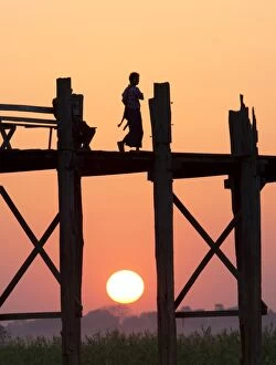 Wooden Post Gallery: Local man walking on the famous U Bein teak bridge at sunset, near Mandalay, Myanmar (Burma), Asia