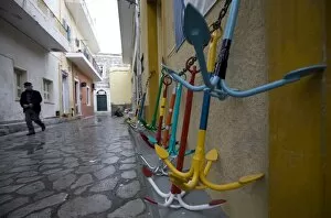A local man walks past traditional Greek anchors for sale outside a chandlers store