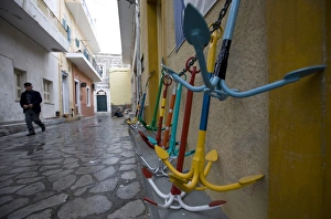Images Dated 24th December 2008: A local man walks past traditional Greek anchors for sale outside a chandlers store