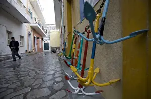 Fisherman Prints: A local man walks past traditional Greek anchors for sale outside a chandlers store