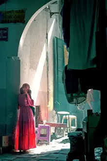 Medina Prints: A local in traditional dress stands in the maze-like medina of Tunis