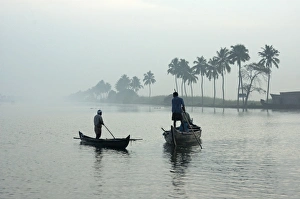 Images Dated 21st February 2006: Local villagers paddle shell dredging canoes at sunrise on the backwaters
