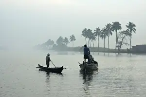Alleppey Prints: Local villagers paddle shell dredging canoes at sunrise on the backwaters