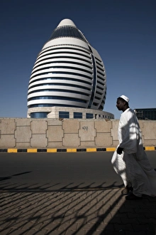 Images Dated 25th January 2000: Locals walk past the 5-star Boji Al-Fateh Hotel (Libyan Hotel)