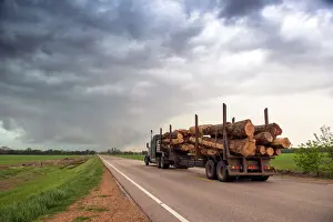 Stormy Sky Prints: Logging truck in Mississippi driving into the heart of a thunderstorm with an extreme tornado watch