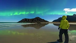 40 44 Years Prints: Lone hiker admiring mountains and cold arctic sea under the Aurora Borealis (Northern Lights)