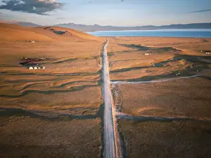 Hues Prints: A long, dusty road stretches across the vast landscape of Song Kol Lake area, Kyrgyzstan