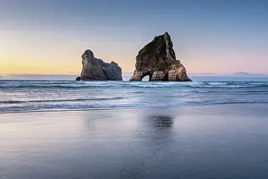 Zealand Prints: Long exposure of Archway Islands reflecting in wet sand at sunset on Wharariki Beach in New Zealand
