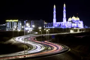 Muscat Prints: Long exposure cityscape night shot with a blue mosque and a street with car trails