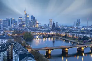 Hesse Prints: Long exposure of clouds at dusk over the illuminated city skyline and Ignatz Bubis bridge