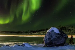Northern Prints: Long exposure of Jeep lights trails under the Aurora Borealis over Great Slave Lake in Northwest Territories