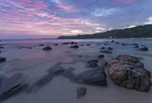 Tangalle Prints: Long exposure of a pink sunset at the beach during dusk with rocks in the foreground