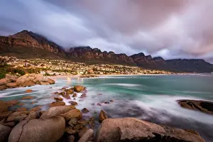 Slow Shutter Prints: Long exposure at sunset at Camps Bay with cloud over Table Mountain and the Twelve Apostles