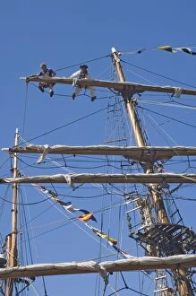 Whitehaven Collection: Detail of main mast of tall ship with two seamen on top yard securing sail